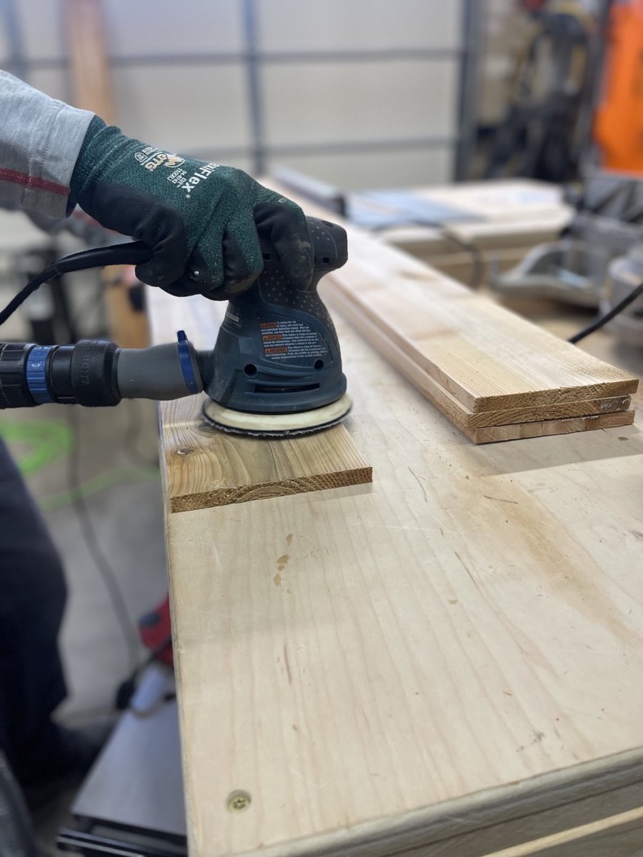 Sanding a cedar board in the workshop